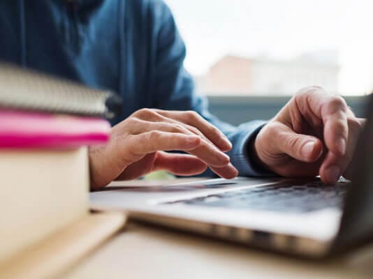 A person typing on a laptop.